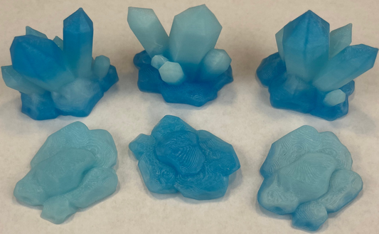Set of blue crystal-like figurines on a textured white surface