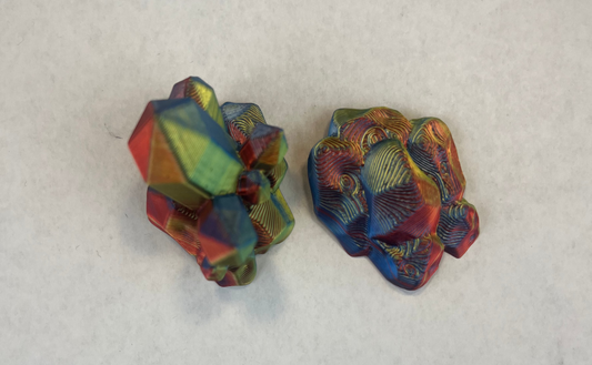 Pair of colorful geometric earrings on a light gray background