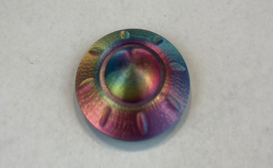 Multicolored metallic object on a light gray background