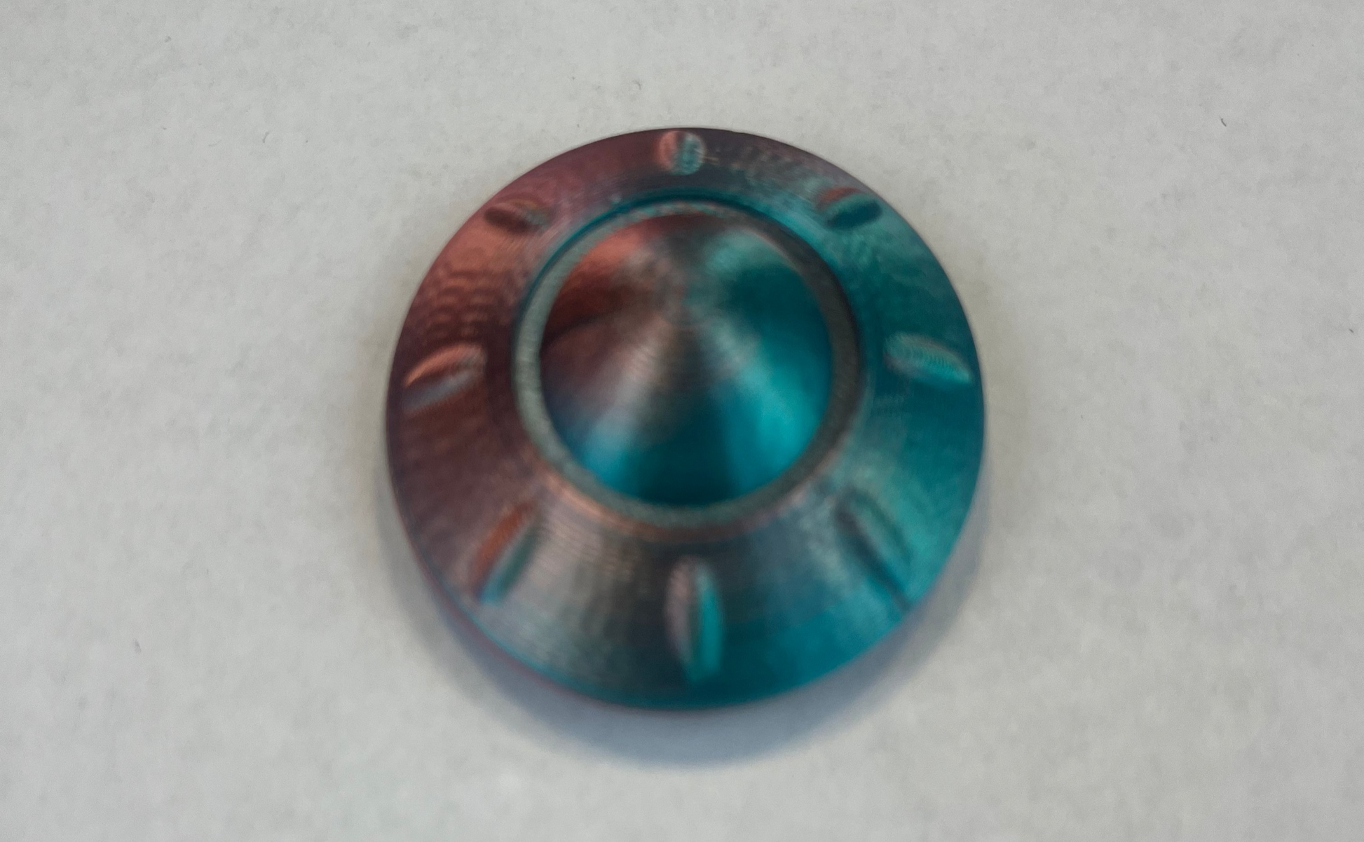 Metallic blue and copper-colored knob on a light gray background