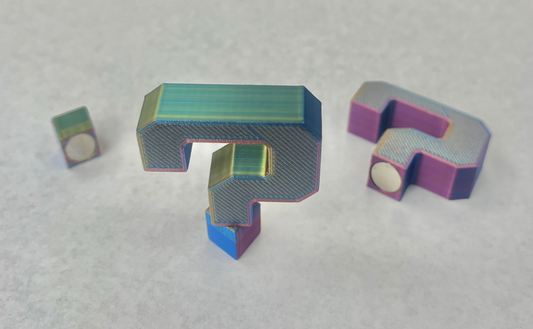 Magnetic question mark shaped hat brim pins in various colors.