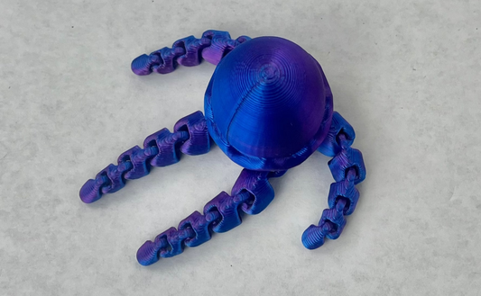 A blue magnetic jellyfish-shaped accessory with multiple tentacles, placed on a white surface.